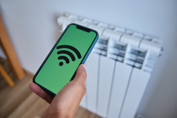 Woman controlling smart home with an application on her mobile phone. Smart home automation...