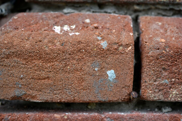 The wall is made of old red brick