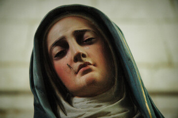 wooden statue of Mary  with a spider in the face