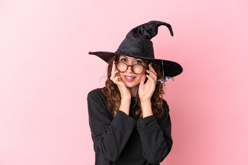 Young caucasian woman celebrating halloween isolated on pink background with glasses and surprised