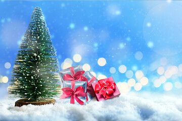 Christmas tree and gift boxes on snow. Christmas concept.