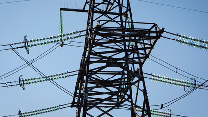 power line construction of cable supports and insulators. High voltage power line on blue sky background in Sunny day. Close-up