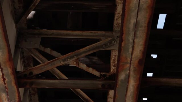 Under rusted and dirty elevated train tracks in Chicago's south side. Close Train Passes overhead. 