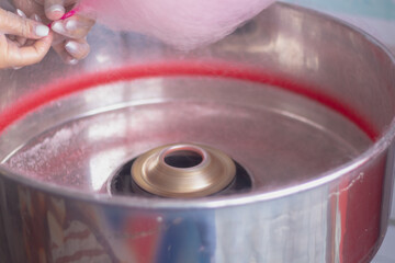 Making cotton candy from sugar, pink cotton candy on a stick