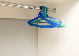 Plastic hangers hang in a new, empty closet. Clothes hangers.