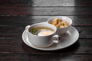 Asian noodle soup, ramen with chicken, vegetables and egg in white bowl