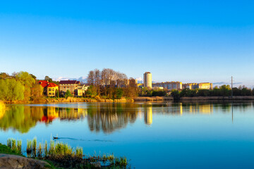 Fototapeta na wymiar A wide blue lake and residential buildings on the far shore