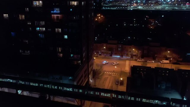 Aerial View Of Chicago Police Blocking Street As El Train At Night Passes By. Between Two Buildings, UHD