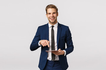 You have to see this. Cheerful elegant male entrepreneur in classic suit, tie, holding digital...