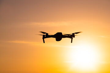 The drone is in flight at sunset . Video shooting from above. An article about the choice of a quadrocopter. Pros and cons of the drone.