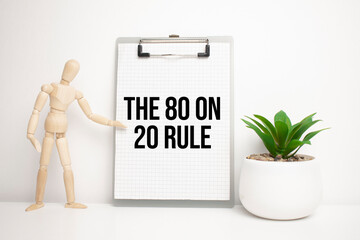 Wooden man shows with a hand to white board with text The 80 on 20 Rule