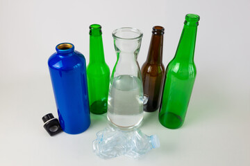Aluminum water bottle, carafe and glass bottle, with a crumpled plastic bottle next to it. Plastic...
