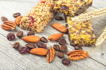 Healthy cereal bars with granola, nuts, dried fruits and coffee beans on a wooden background