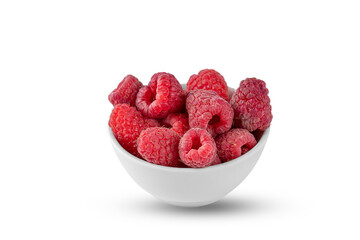 ripe red raspberries in a ceramic bowl isolated on a white background