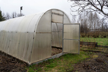 Fototapeta na wymiar greenhouse with an open door on a spring day