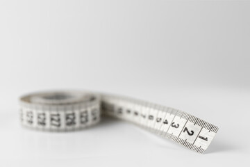 soft two sided tape measure roll isolated on a white and gray background with copy space