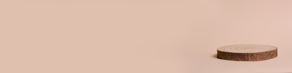 Round wooden shape of a saw cut tree on a beige background. Empty stage showcase for your product presentation.?opy space for text. Banner