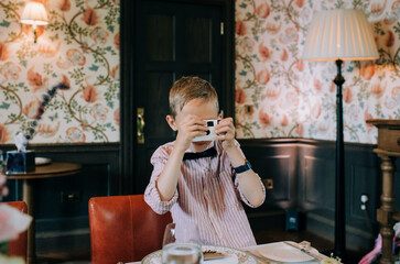 boy taking pictures with disposable camera at a wedding