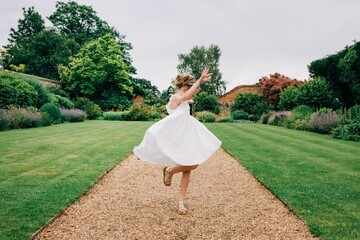 flower girl dancing in a beautiful dress around a country garden