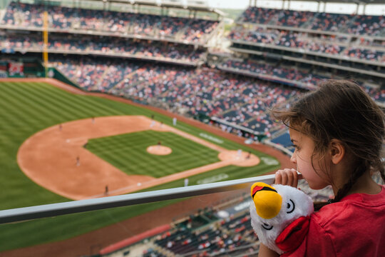 little girl watching baseball game from the stands
