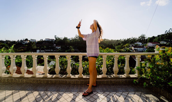 woman making a selfie in a viewpoint tells the sunset