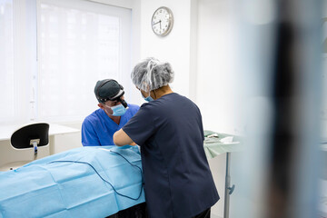 Surgeons performing eyelid surgery to anonymous patient