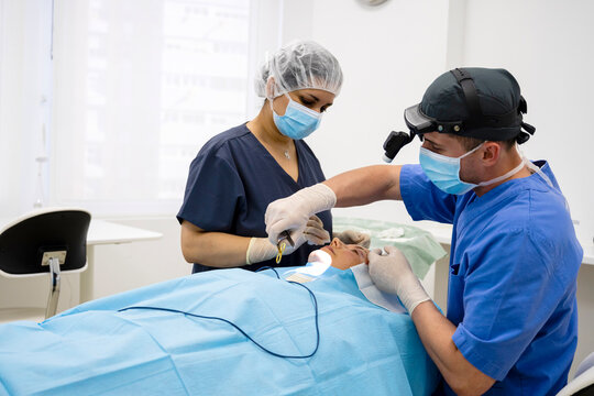 Surgeon sutures the eyelid after plastic surgery operation