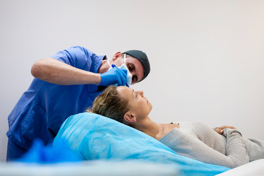 Surgeon drawing line on girl eye with marker preparing for procedure.