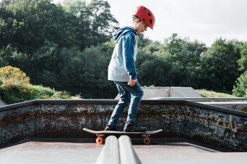 boy skateboarding with a helmet on at a skate park in the UK
