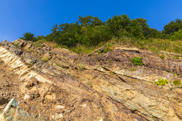 Cliffs of the steep coast of the Pacific Ocean in Kamchatka, interesting geological structures of the cliff.