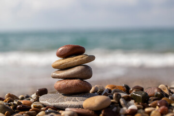 natural stones lined up on the beach, there is a sea view in the background.