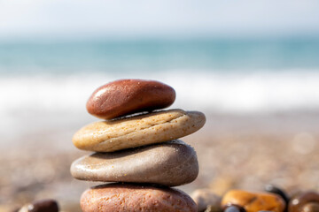 natural stones lined up on the beach, there is a sea view in the background.