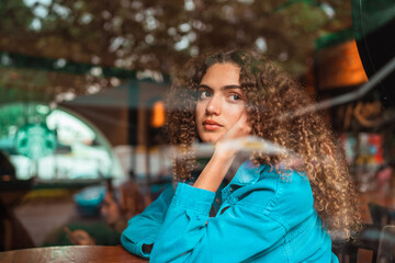 curly haired girl looking through the window