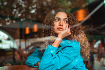 curly haired girl looking through the window