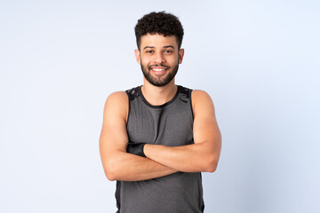 Young Moroccan man isolated on blue background with arms crossed