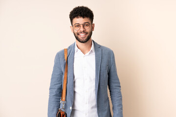 Young business Moroccan man isolated on beige background with glasses and happy