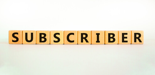 Subscriber symbol. The word Subscriber on wooden cubes. Beautiful white table, white background. Business and subscriber concept. Copy space.