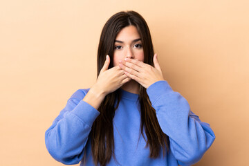Teenager Brazilian girl over isolated background covering mouth with hands