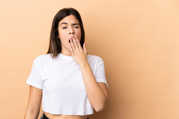 Teenager Brazilian girl over isolated background yawning and covering wide open mouth with hand