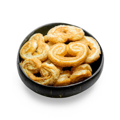 Close-up of sweet puff pastry cookies baked in wooden bowl isolated on white background. Palmiers biscuits.