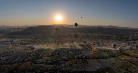 Panoramic view of bunch of colorful hot air balloon flying against sunrise in Cappadocia, Turkey in love valley located in Goreme national park