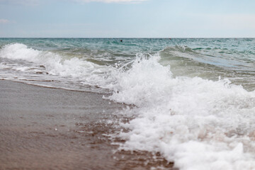 view from the beach, there are waves in the sea.