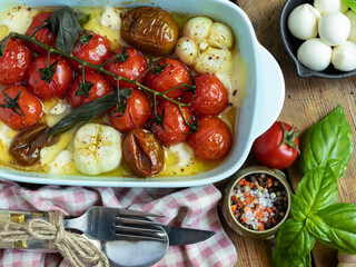 Baked vegetable tomato, basil, mozzarella cheese, garlic in the oven in ceramic dishes. cooking, cooked dish close-up