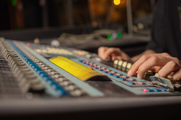 music, technology, people and equipment concept - man at mixing console in sound recording studio...