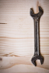 Metal wrench on a wooden background