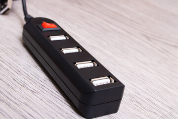 Black USB hub on a wooden background