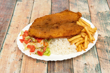 Colombian combo dish, valluna cutlet with veal milanesa, french fries, cooked white rice and tomato and lettuce salad