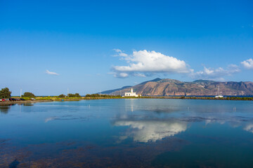 Salina island (Aeolian archipelago), Messina, Sicily, Italy, 08.17.2021: view of the salt lake with the white lighthouse in the background in Punta Lingua.