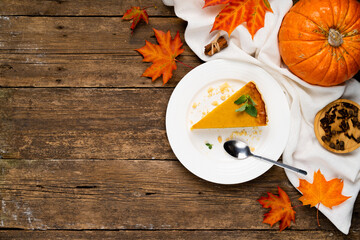 a piece of pumpkin pie on the wooden table on the right, pumpkin and autumn leaves, copy the space on the left