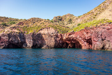 Fototapeta na wymiar Lipari island (Aeolian archipelago), Messina, Sicily, Italy: view of the seacoast with caves and red rock.